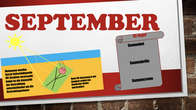 Das Bild stellt ein Poster dar, dass an einer Steinwand befestigt wurde. Darauf zu sehen ist als Überschrift in Großbuchstaben "September". Zudem ein Liste der 3S-Regeln (Sonnenhut, Sonnenbrille, Sonnencreme), sowie eine Person, die sich sonnt und sichtlich von der Sonne einen Sonnenbrand bekommt. Neben der Person steht geschrieben: "Melanome werden durch Zellschädigende UV-Strahlen verursacht. Dabei ist die Intensität der Bestrahlung entscheidender als die Bestrahlungsdauer. Hohe UV-Belastung in der Kindheit erhöht das Hautkrebs-Risiko beträchtlich."